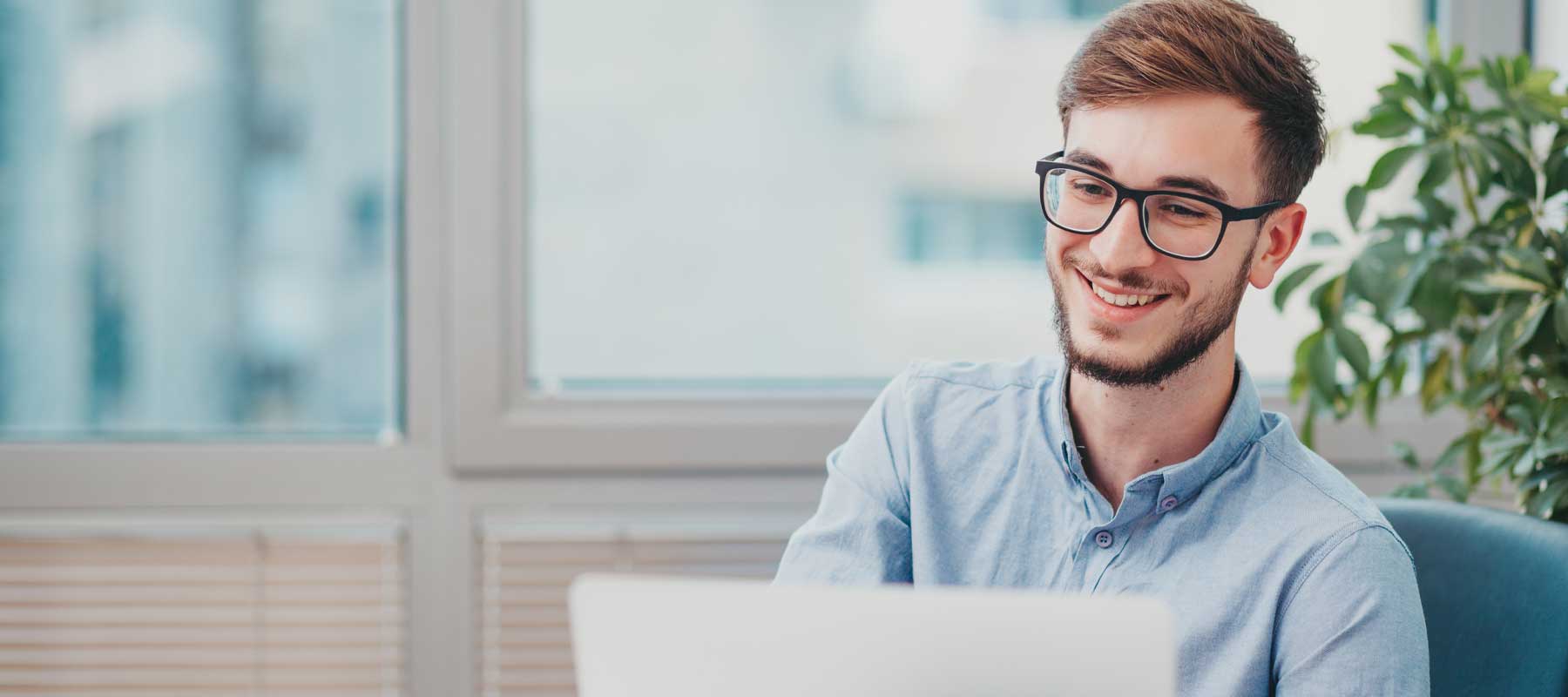 Homme souriant devant un ordinateur